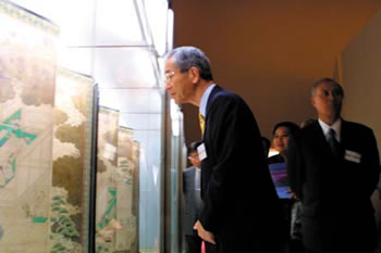 Chairperson Ishikawa is charmed by a folding screen representing tea production